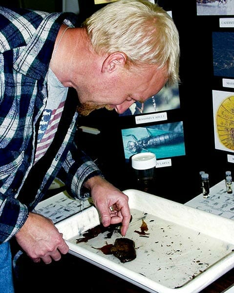 Biologist Chad Augustin demonstrating how freshwater insects assess water quality at a watershed meeting