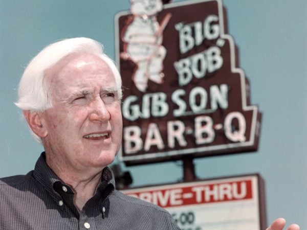 Don McLemore standing in front of the Big Bob Gibson Bar-B-Q sign