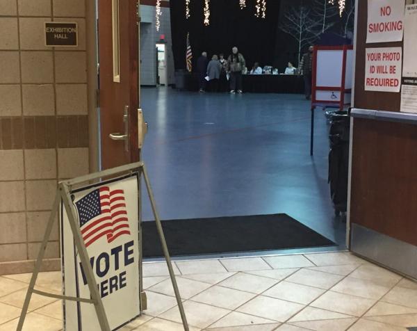 entrance to a polling place, featuring a Vote Here sign