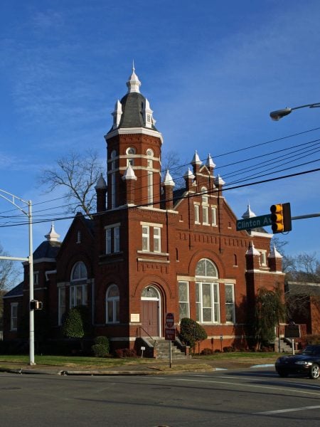 Exterior view of a red brick synagogue at a street intersection